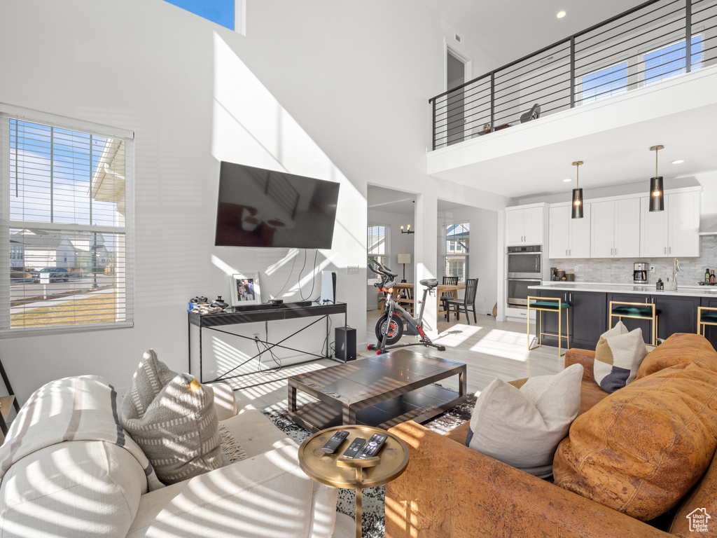 Living room featuring light wood-type flooring and a high ceiling