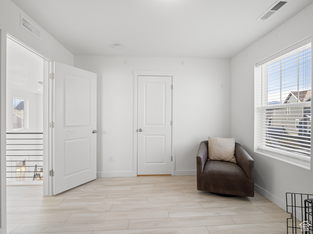 Living area with visible vents, light wood-type flooring, and baseboards