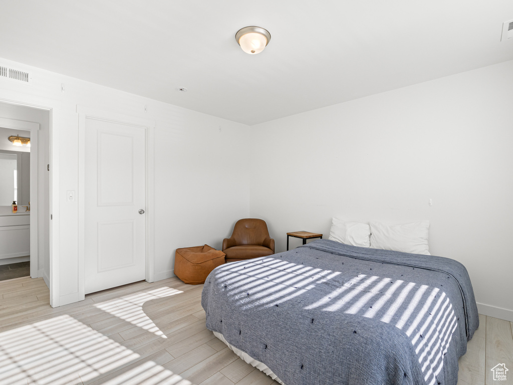 Bedroom with light wood-style flooring, baseboards, and visible vents