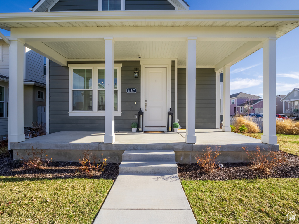 Doorway to property featuring a porch and a residential view