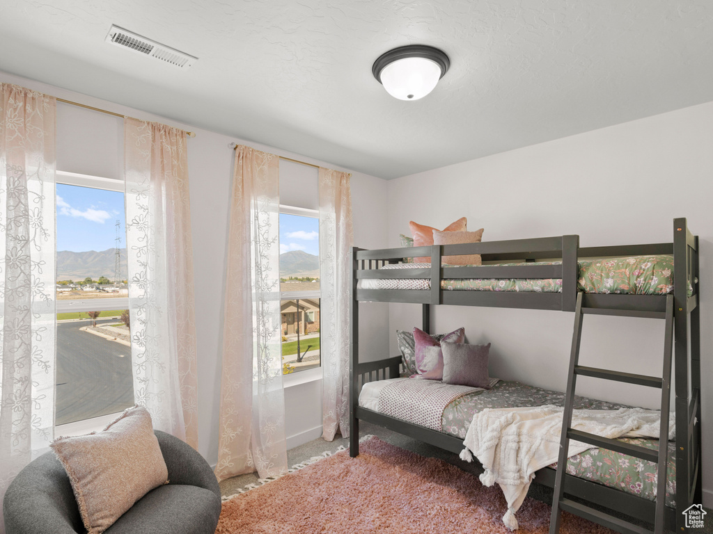 Bedroom with carpet flooring, a mountain view, and visible vents
