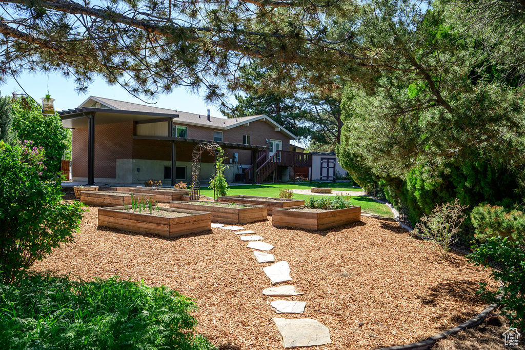 View of yard with a storage shed, stairway, an outbuilding, and a vegetable garden