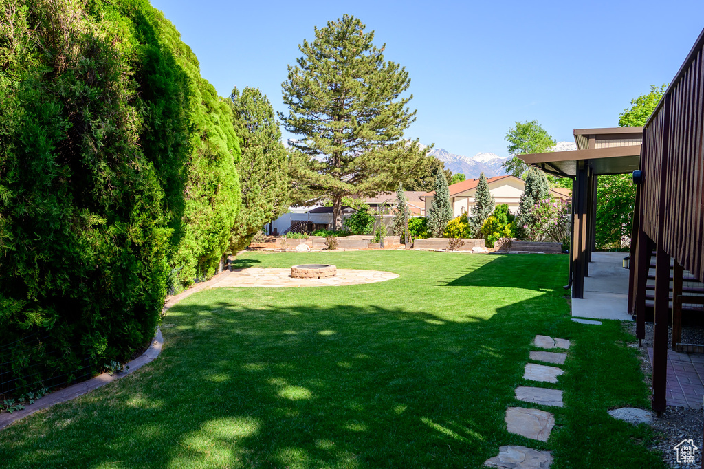 View of yard featuring a patio, a mountain view, and an outdoor fire pit