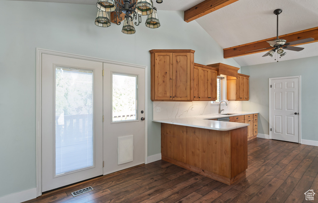 Kitchen featuring visible vents, a peninsula, light countertops, lofted ceiling with beams, and ceiling fan with notable chandelier