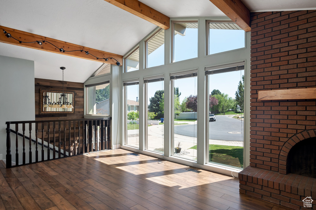 Unfurnished living room with lofted ceiling with beams and hardwood / wood-style floors