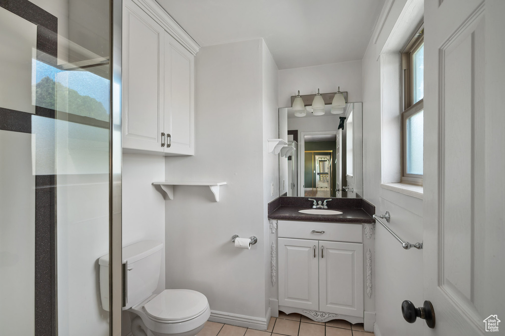 Bathroom with toilet, tile patterned flooring, and vanity