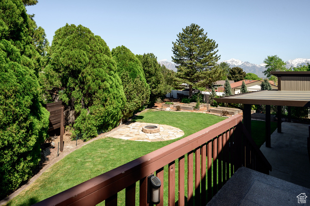 View of yard featuring a patio, fence, a fire pit, and a mountain view