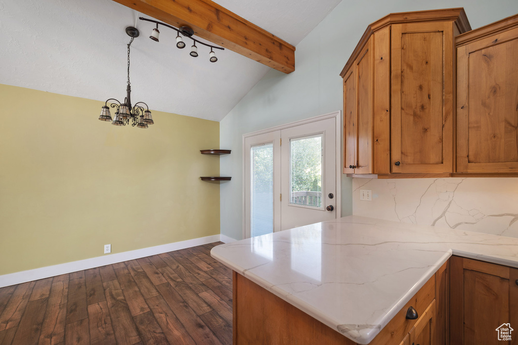 Kitchen featuring dark wood-style flooring, a peninsula, baseboards, vaulted ceiling with beams, and brown cabinets