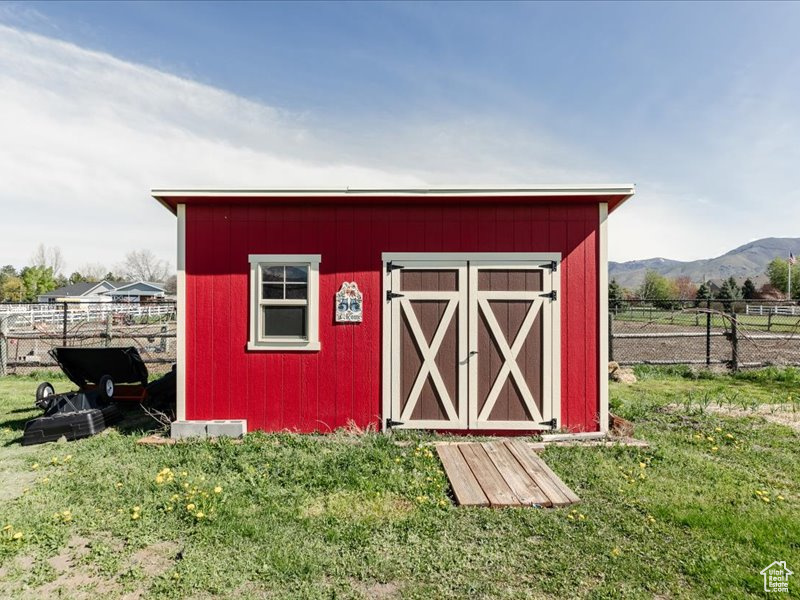 View of shed featuring a mountain view and fence