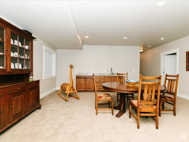 Dining space featuring indoor wet bar, recessed lighting, baseboards, and light carpet