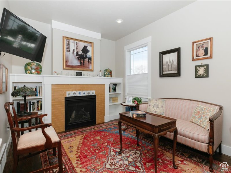 Living area featuring recessed lighting, a fireplace with flush hearth, and wood finished floors