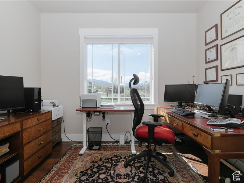 Office area with dark wood-type flooring and baseboards