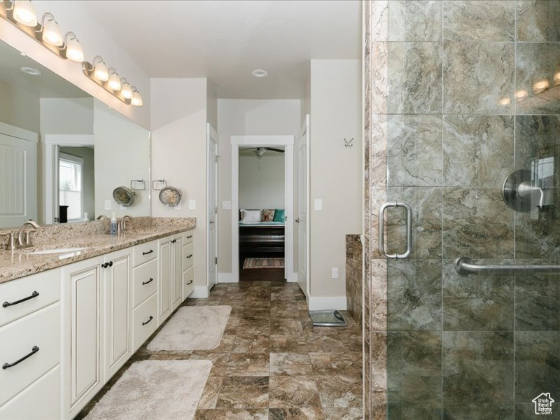 Full bathroom with baseboards, a shower stall, and vanity