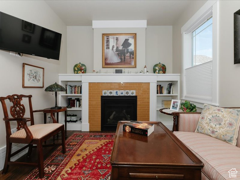Living room featuring wood finished floors, radiator heating unit, and a tile fireplace