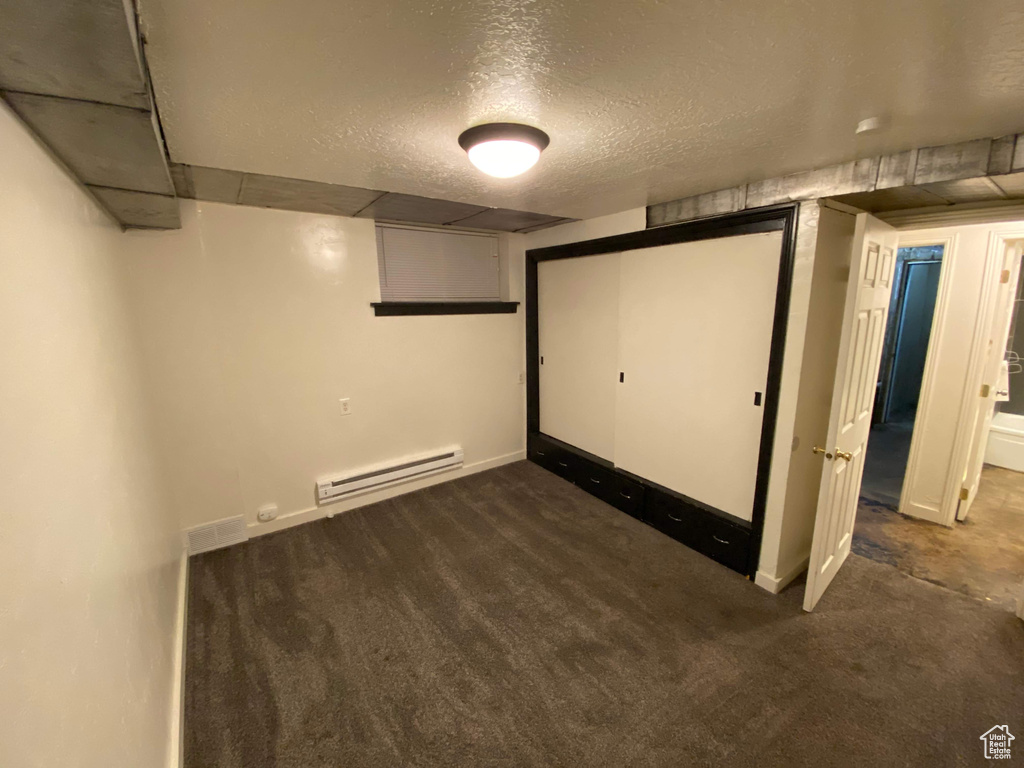 Finished basement featuring carpet floors, baseboards, and baseboard heating