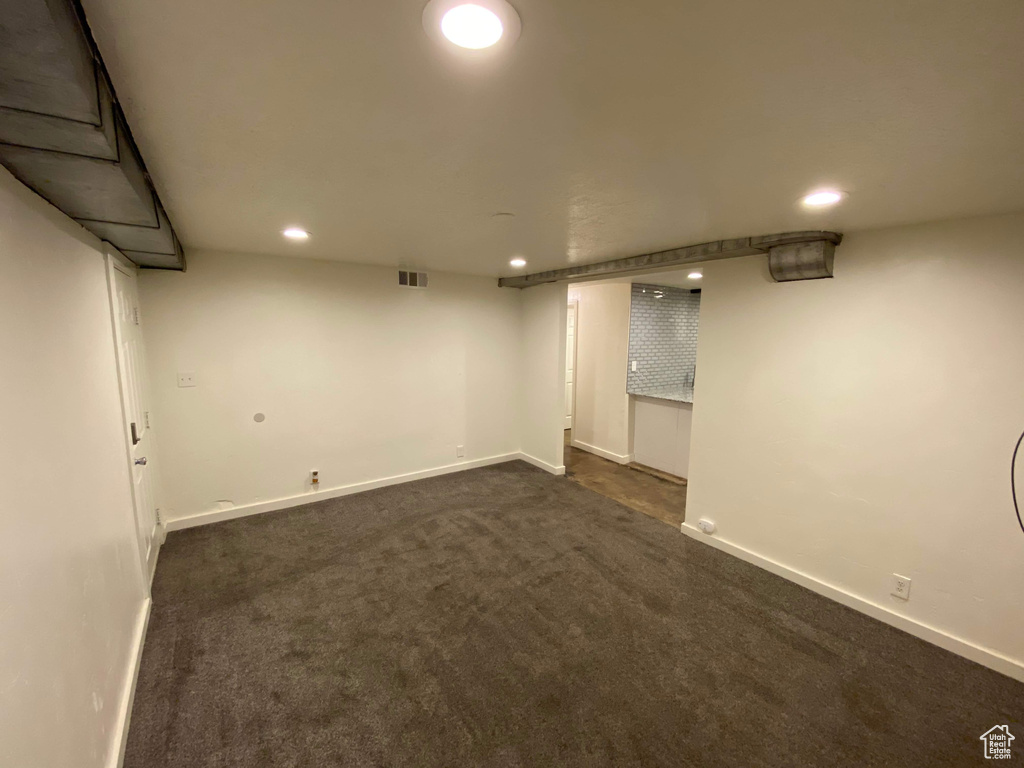 Finished below grade area with recessed lighting, baseboards, visible vents, and dark carpet