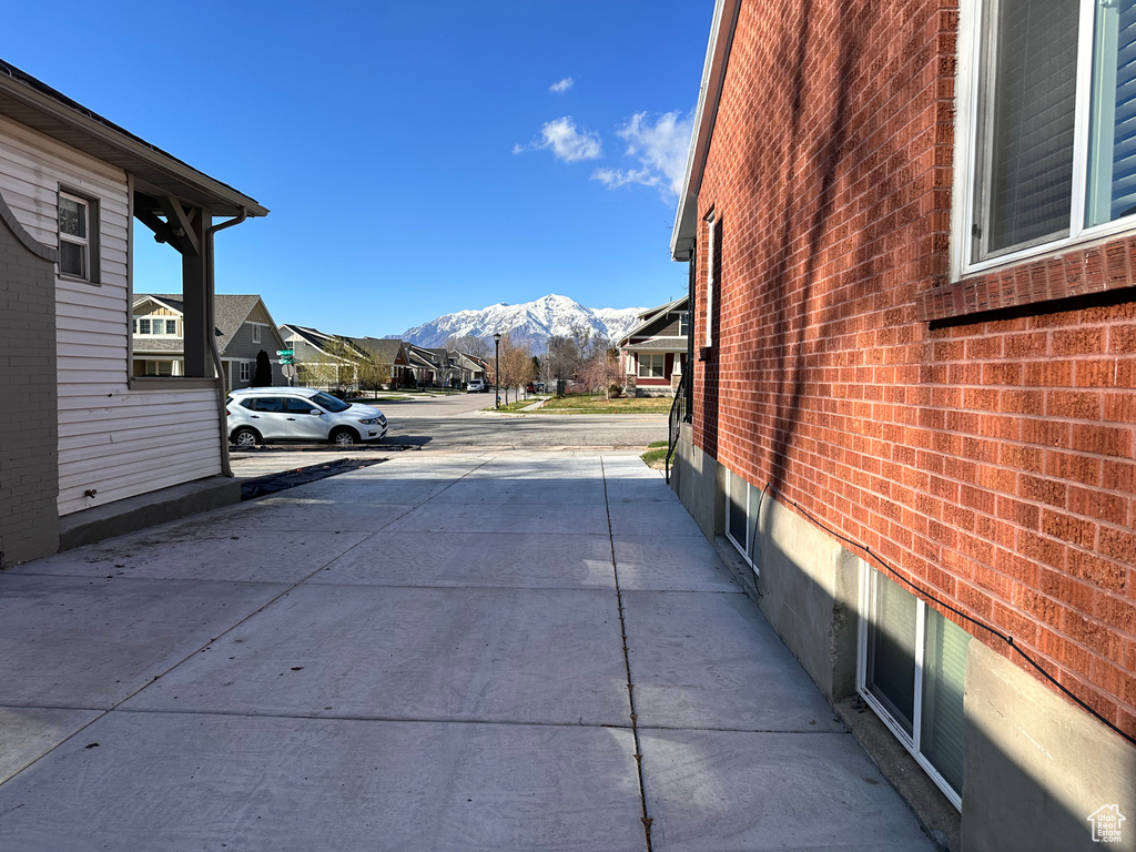 Exterior space featuring brick siding, a mountain view, and a residential view