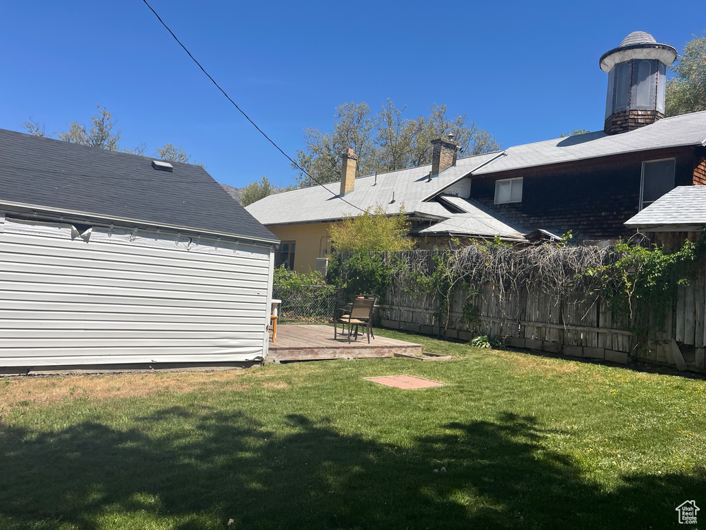 View of yard with fence and a deck