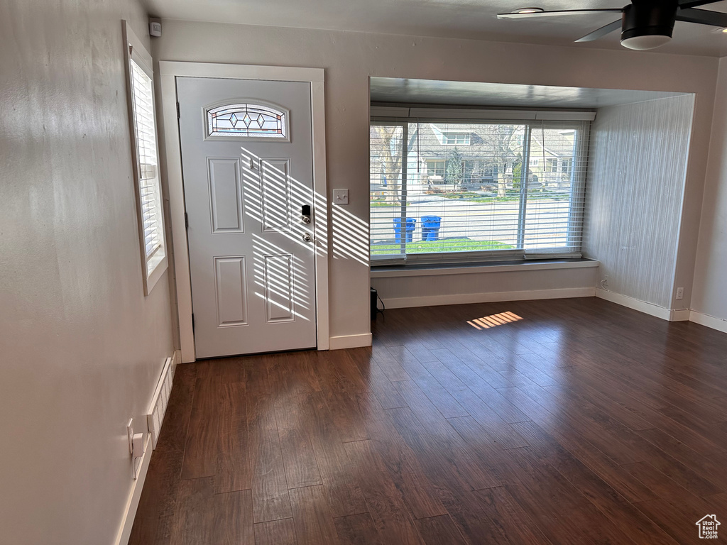 Entryway with plenty of natural light, baseboards, ceiling fan, and dark wood-style flooring