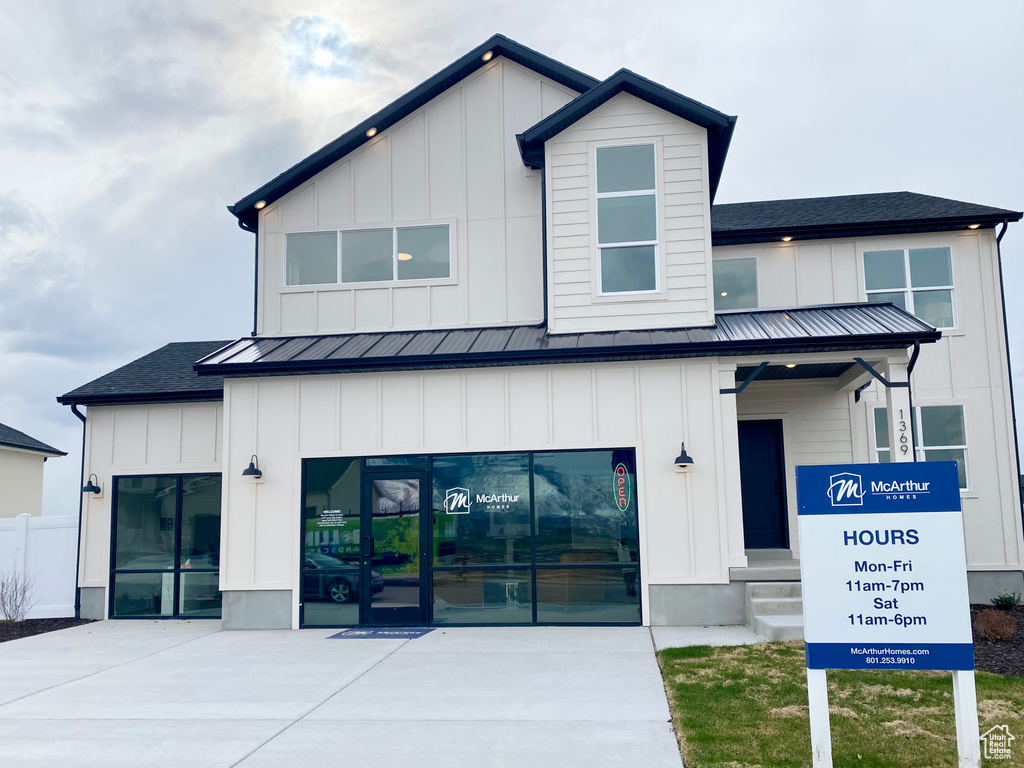 View of front facade featuring board and batten siding, a standing seam roof, and metal roof