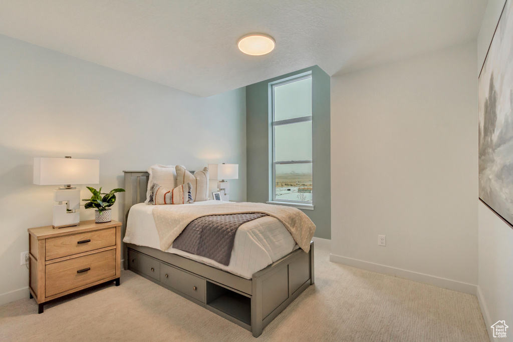 Bedroom featuring baseboards and light carpet