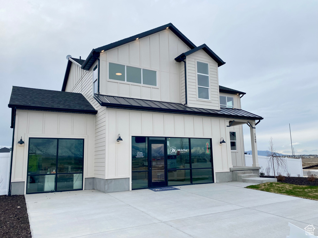 Rear view of house featuring metal roof, a standing seam roof, and board and batten siding