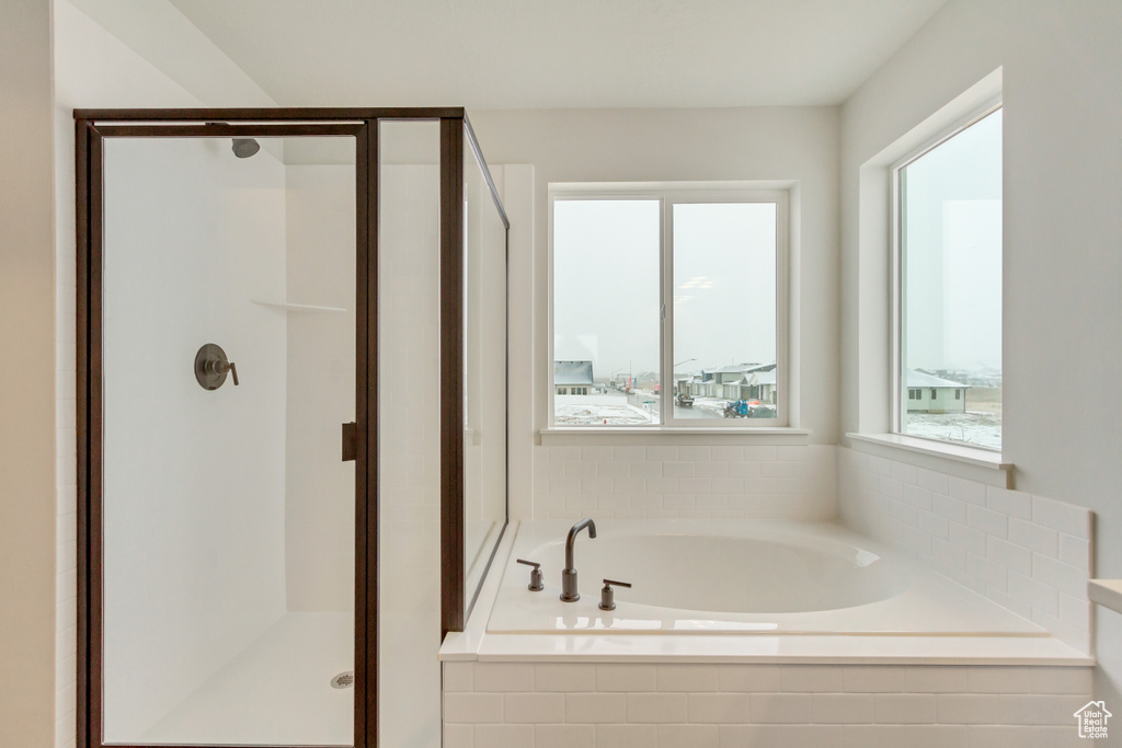 Bathroom featuring a stall shower and a bath