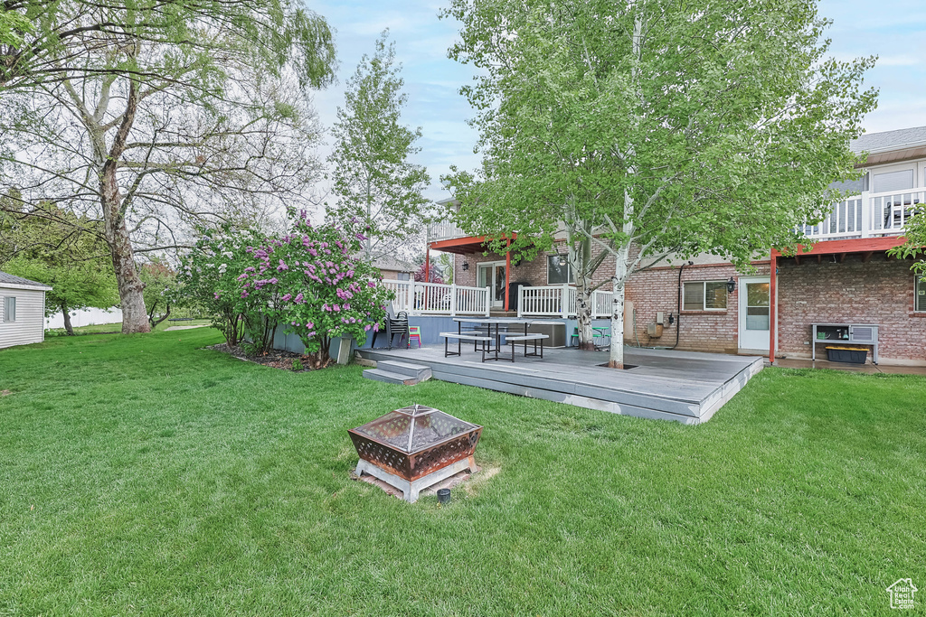 View of yard featuring an outdoor fire pit and a wooden deck