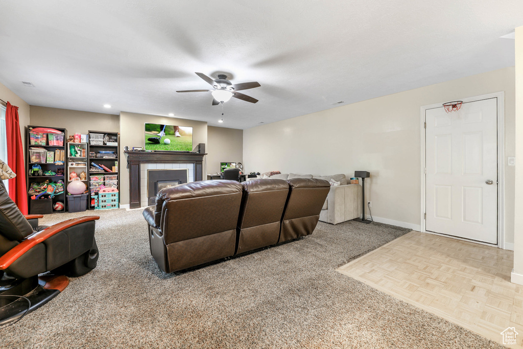 Living room with baseboards, a fireplace, a ceiling fan, and recessed lighting