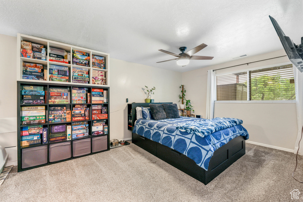 Carpeted bedroom featuring a textured ceiling, baseboards, and visible vents