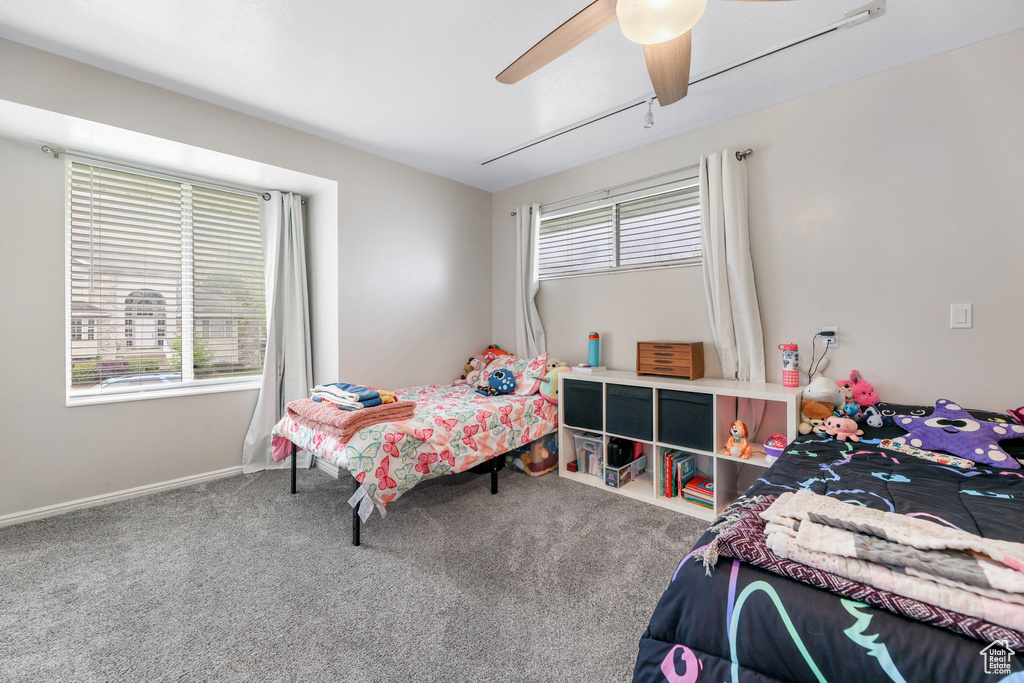 Carpeted bedroom featuring baseboards and ceiling fan