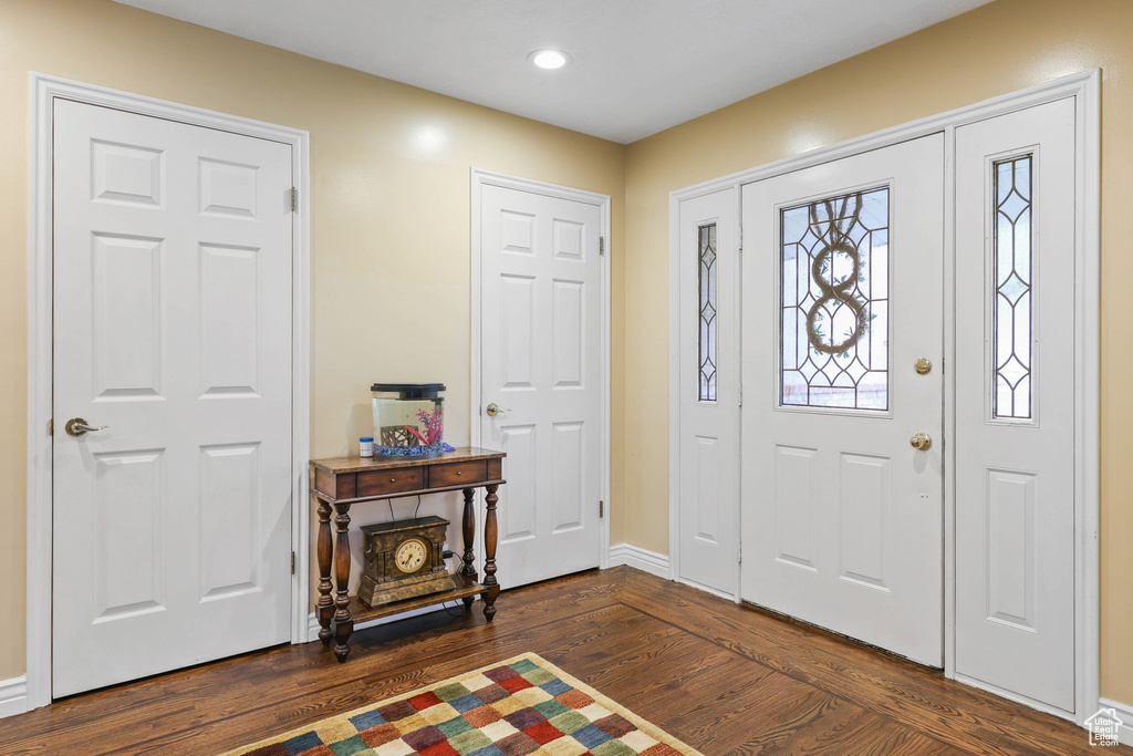 Entryway with dark wood-style flooring, baseboards, and recessed lighting