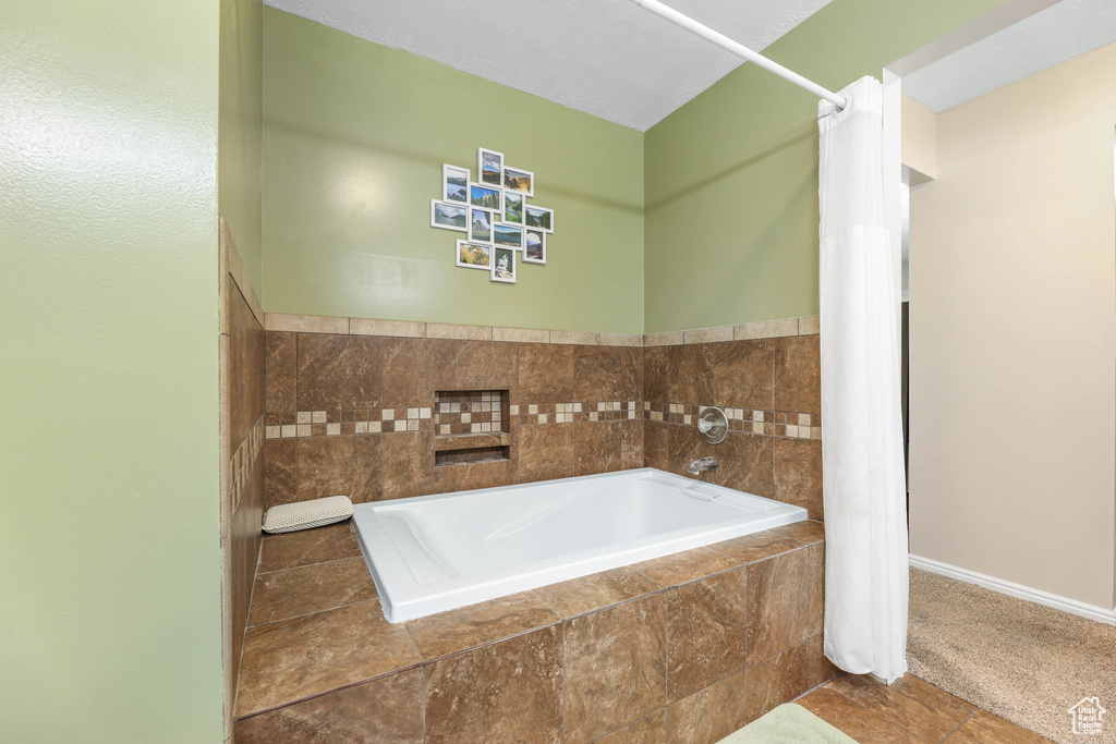 Bathroom featuring baseboards and a bath