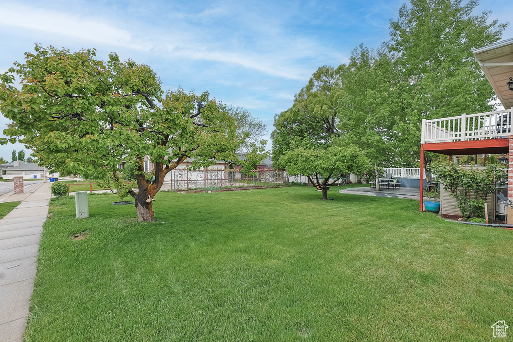 View of yard with a deck and fence