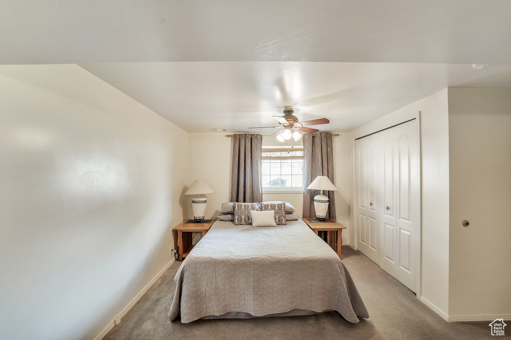 Bedroom featuring carpet floors, baseboards, ceiling fan, and a closet