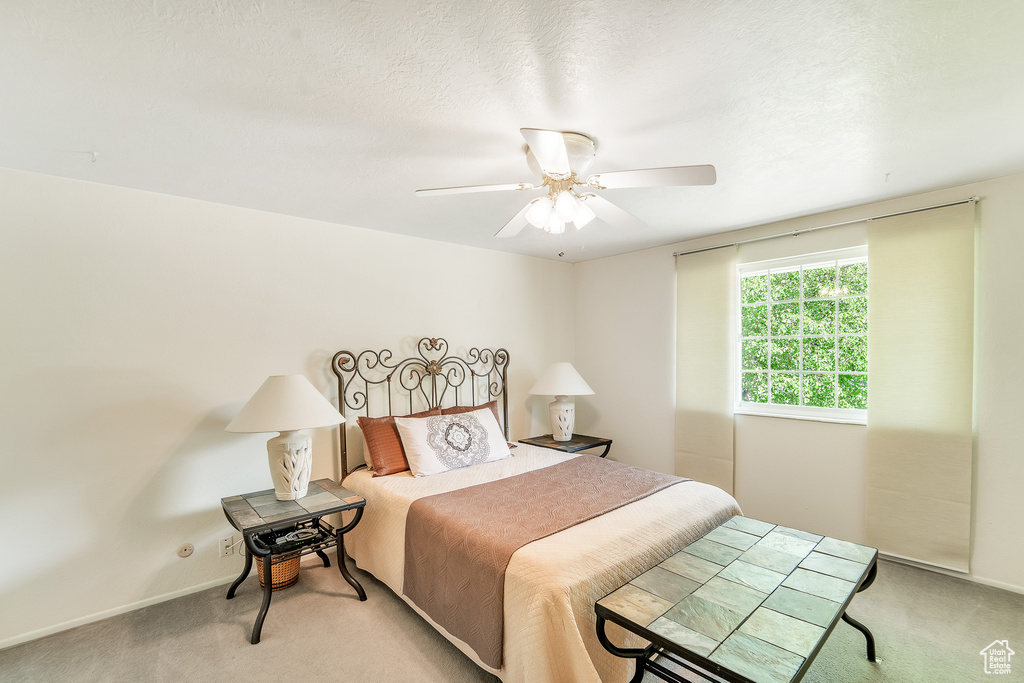 Carpeted bedroom featuring a ceiling fan and baseboards