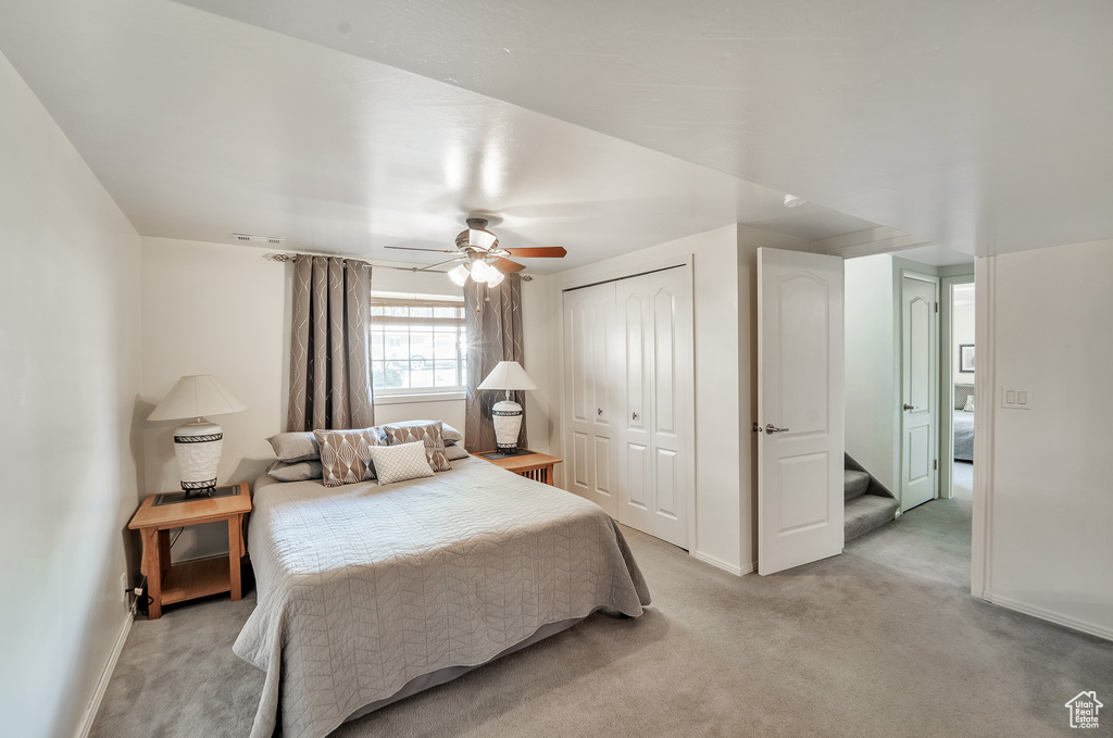 Bedroom with a ceiling fan, baseboards, light carpet, and a closet