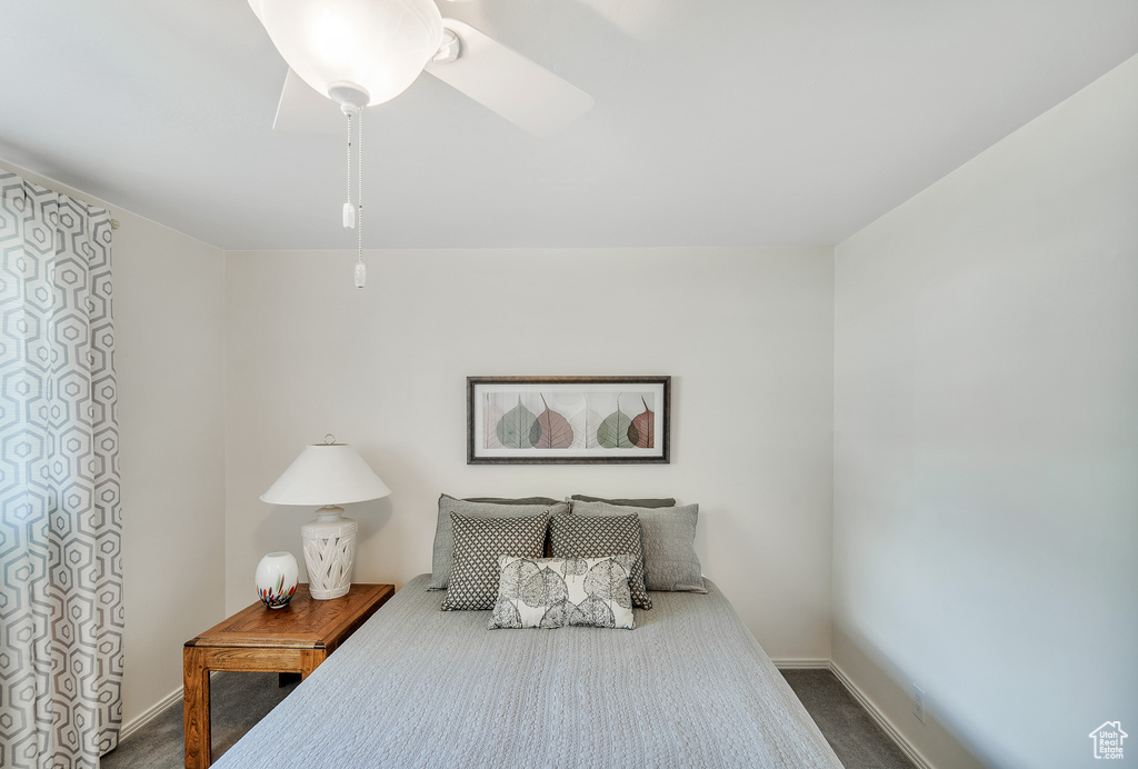 Bedroom featuring baseboards, ceiling fan, and dark colored carpet