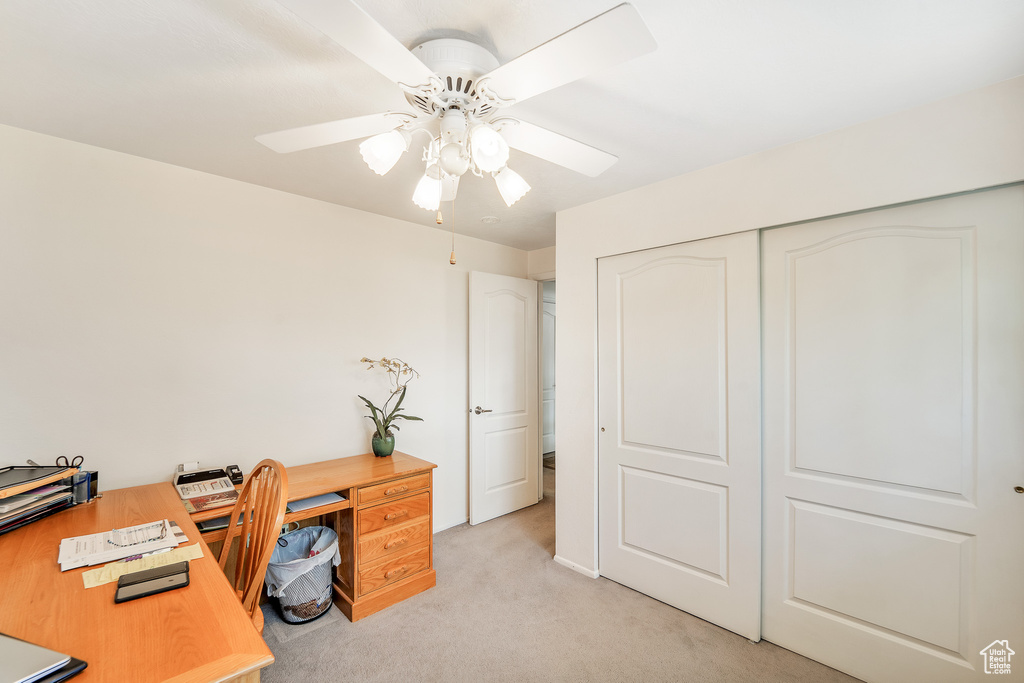 Office with ceiling fan and light colored carpet