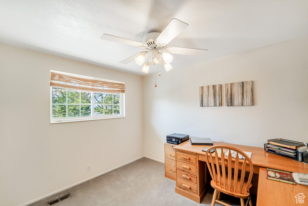 Office featuring visible vents, baseboards, ceiling fan, and light carpet