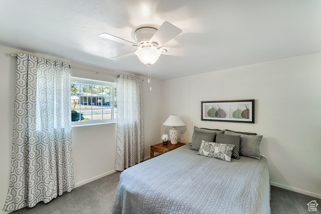 Carpeted bedroom featuring baseboards and ceiling fan