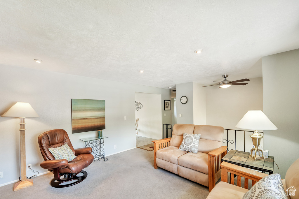Living room featuring carpet floors, ceiling fan, and baseboards