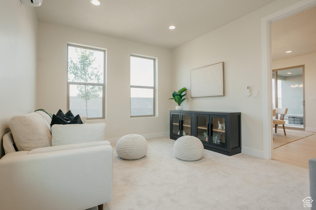 Living room featuring baseboards, carpet, recessed lighting, and a wall mounted AC