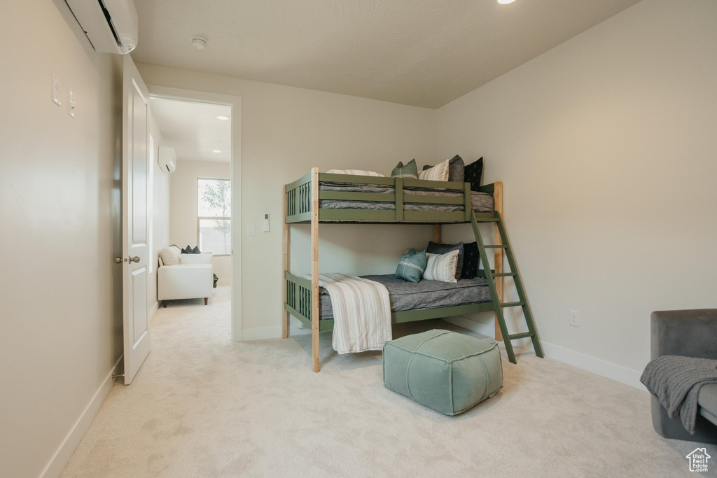 Carpeted bedroom with baseboards, a wall mounted air conditioner, and recessed lighting