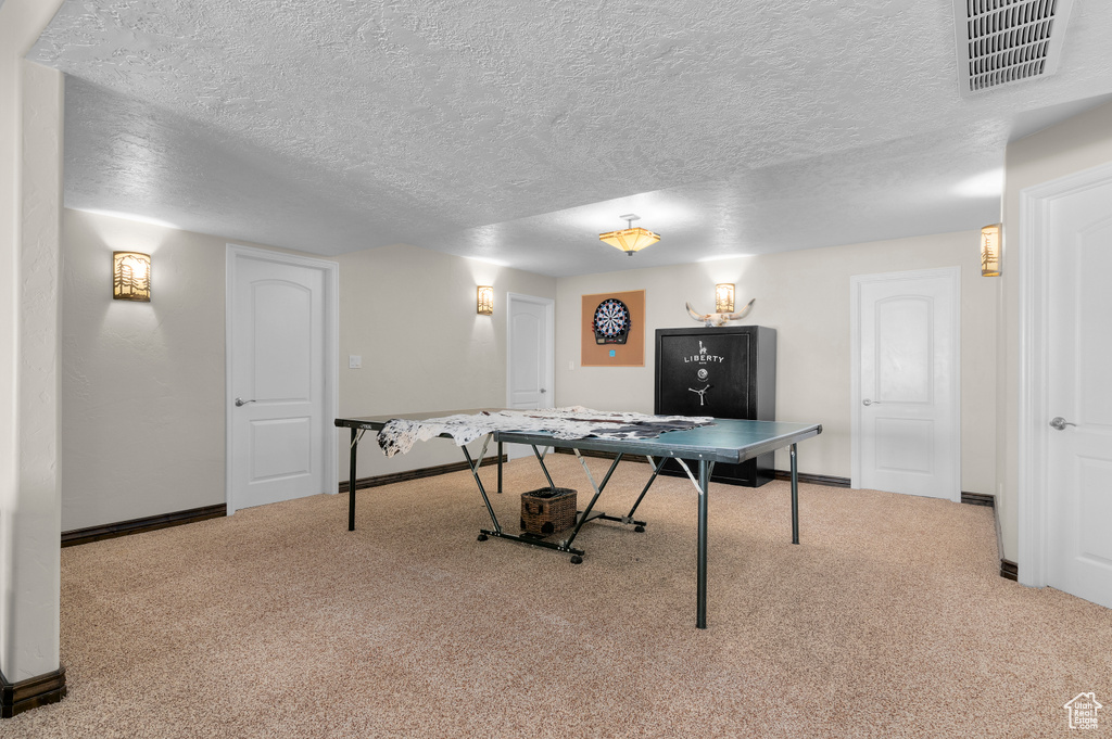 Game room with carpet floors, baseboards, a textured ceiling, and visible vents