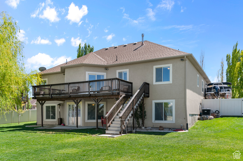 Back of house featuring a deck, a fenced backyard, stairs, and stucco siding