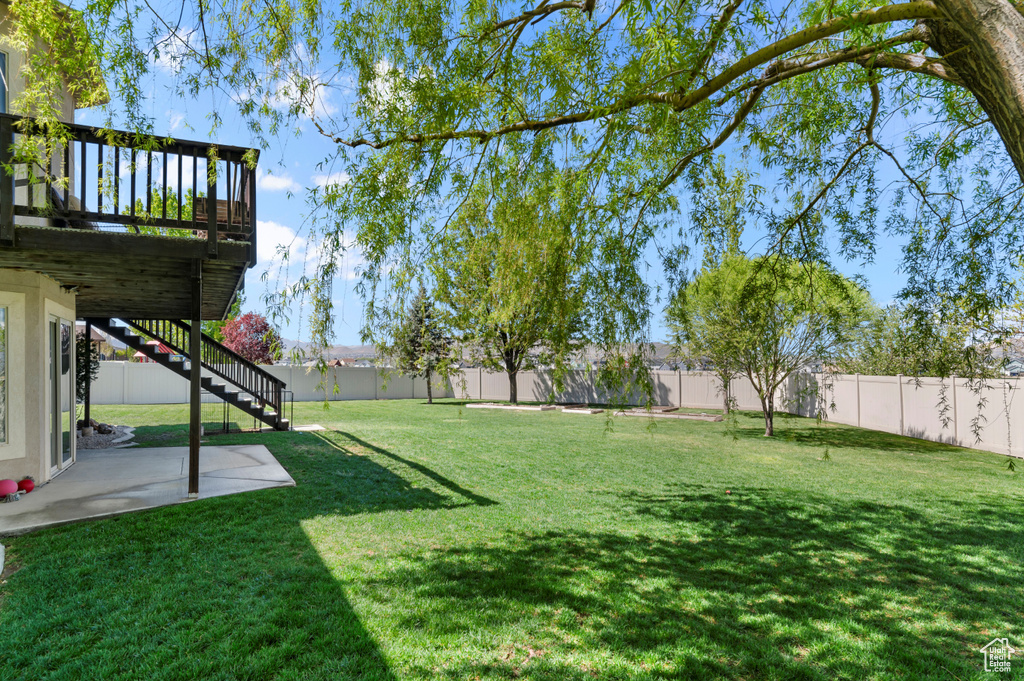 View of yard featuring a fenced backyard, stairs, a patio area, and a wooden deck
