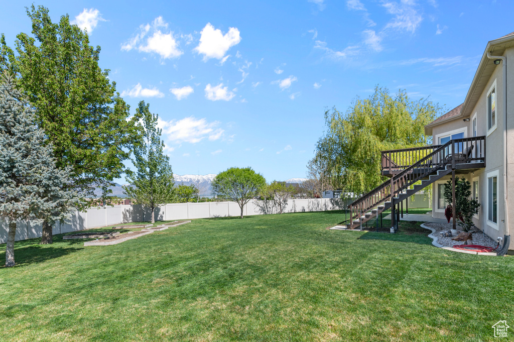 View of yard featuring stairway, a deck, and a fenced backyard