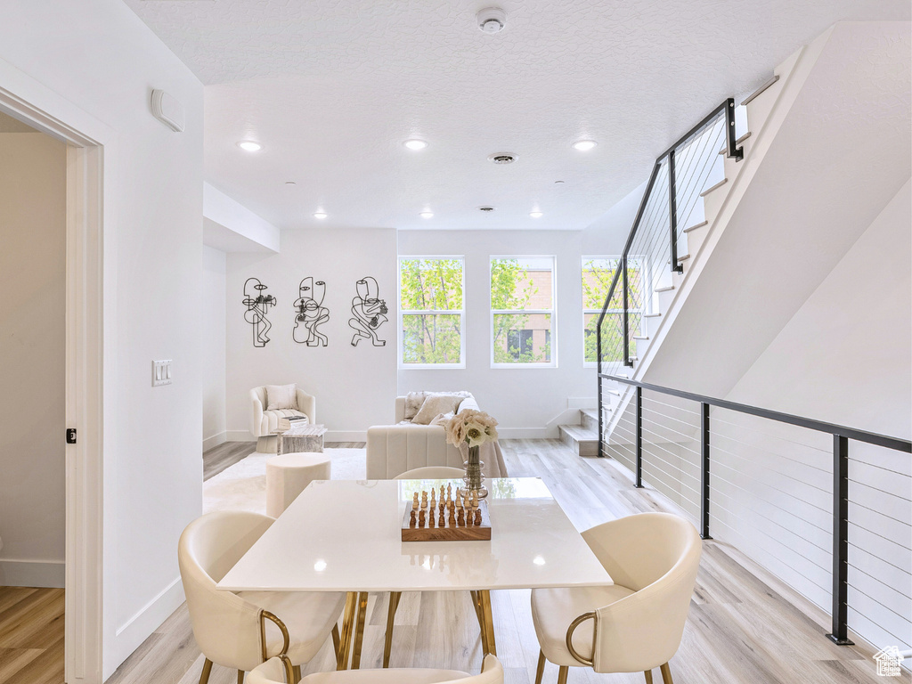 Dining area with light wood-style floors, recessed lighting, baseboards, and stairs