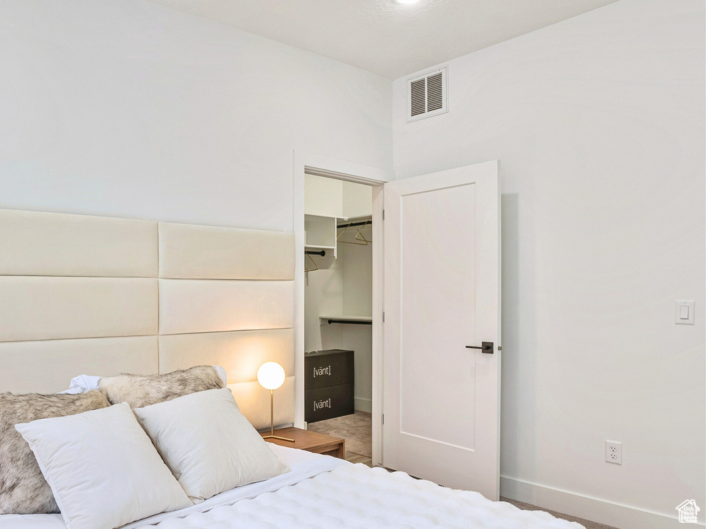 Bedroom with baseboards, visible vents, a spacious closet, and a closet